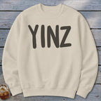 Cream sweatshirt with dark gray "YINZ" text across the chest.