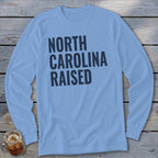 Light blue long sleeve shirt with "NORTH CAROLINA RAISED" in dark blue text.
