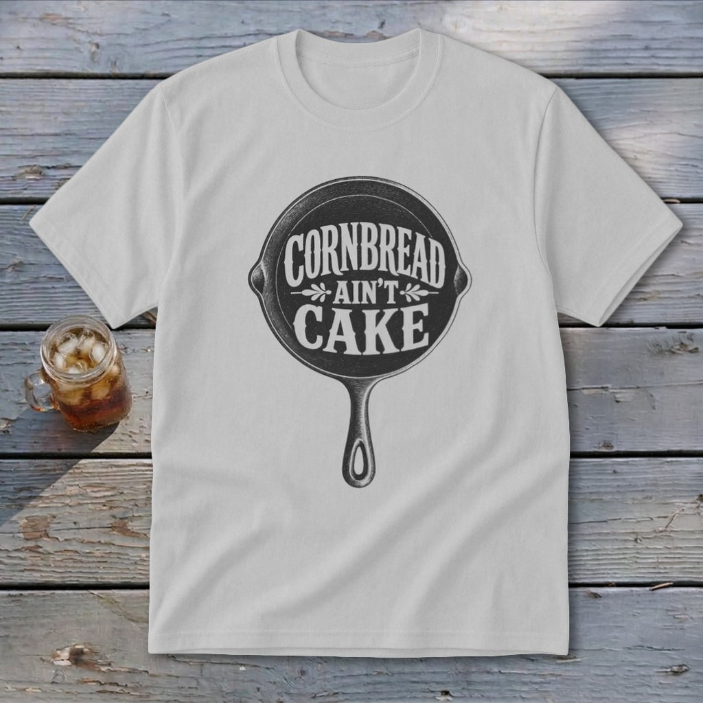 White t-shirt with "Cornbread Ain't Cake" graphic inside a cast iron skillet.