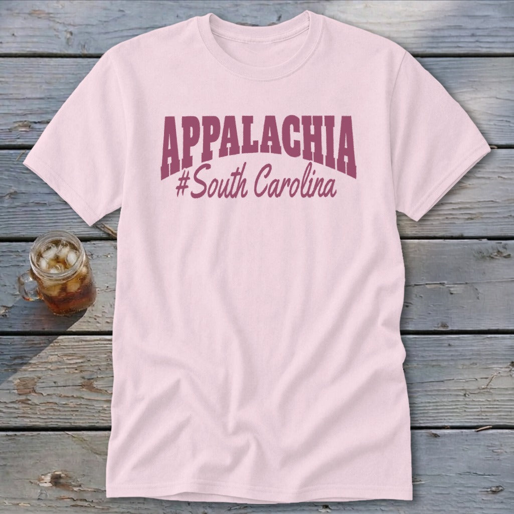 Pink t-shirt with "APPALACHIA #South Carolina" graphic, on a wooden surface.