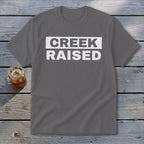 Gray t-shirt with "CREEK RAISED" printed in white text.