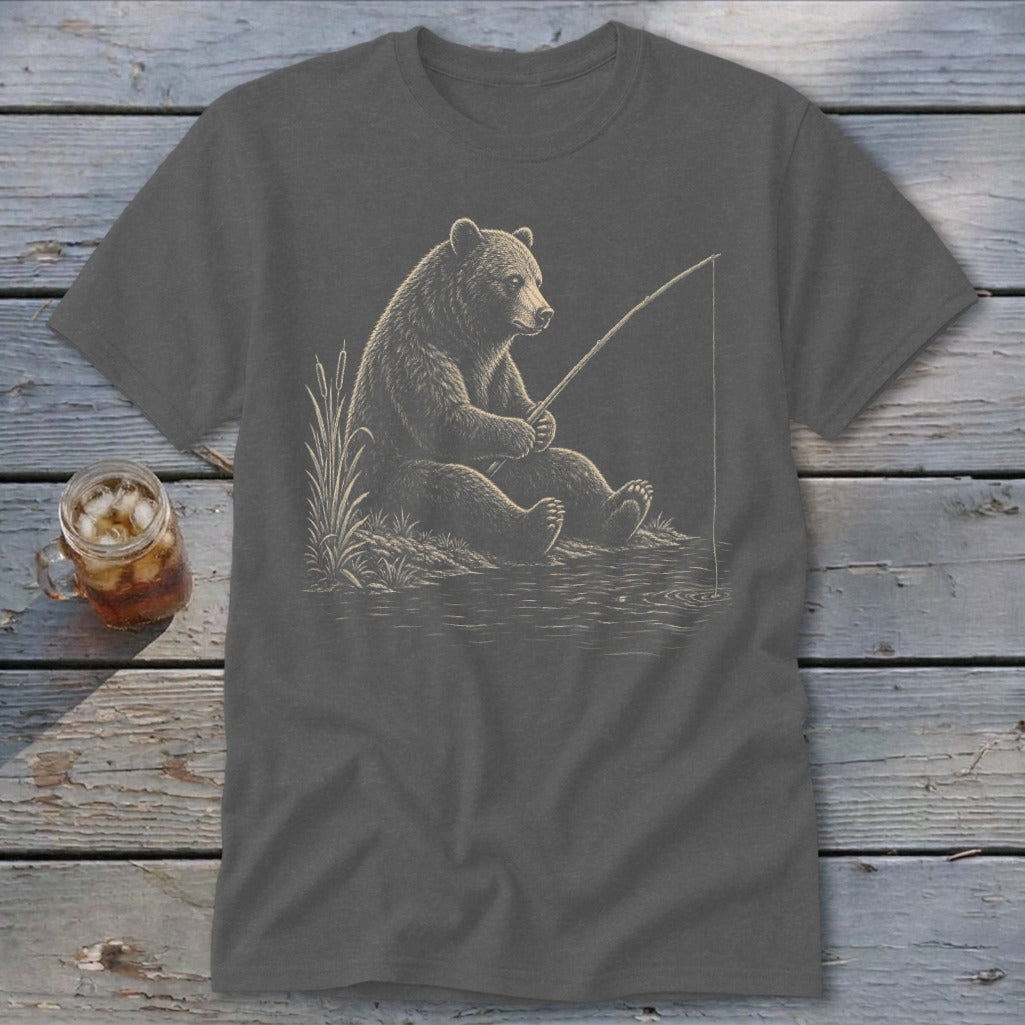 T-shirt graphic of a bear fishing by a lake with reeds and water.
