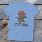 Blue t-shirt with anvil design and "FORGED IN FIRE ROOTED IN STONE" text.