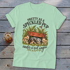 Speckled pup sleeps under red wagon with text "Pretty as a speckled pup".