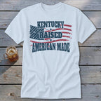 White t-shirt with "Kentucky Raised American Made" and distressed American flag graphic.
