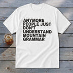 White t-shirt with black text reading "Anymore people just don't understand mountain grammar".