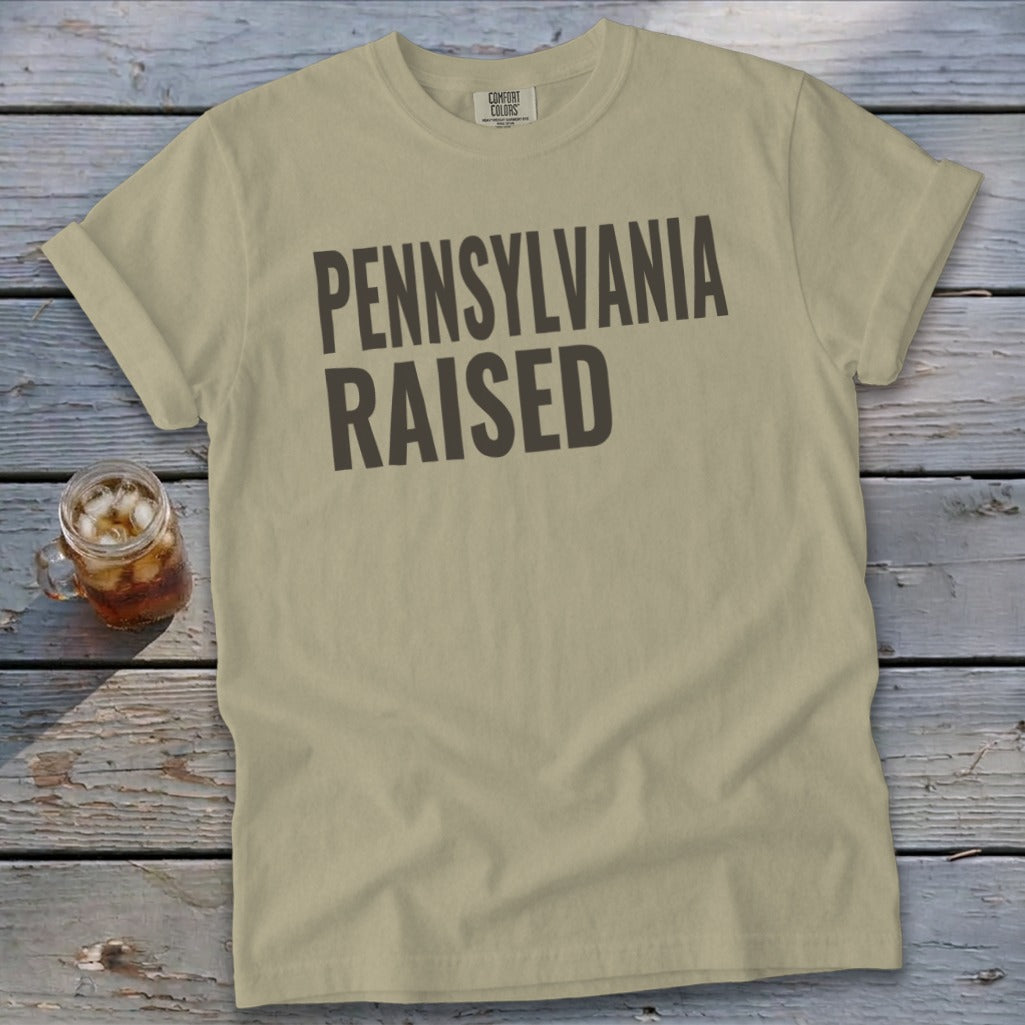 Tan t-shirt with "PENNSYLVANIA RAISED" printed in dark gray.