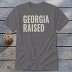 Grey t-shirt with white text reading "GEORGIA RAISED".