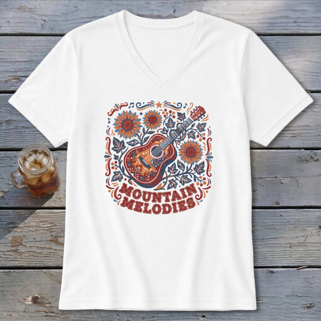 A white V-neck t-shirt featuring a folk-style illustration of an acoustic guitar, sunflowers, and the text MOUNTAIN MELODIES.