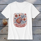 A white V-neck t-shirt featuring a folk-style illustration of an acoustic guitar, sunflowers, and the text MOUNTAIN MELODIES.