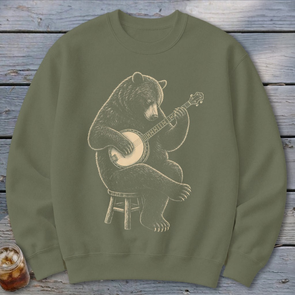 Bear sitting on stool playing a banjo, illustration on olive green sweatshirt.