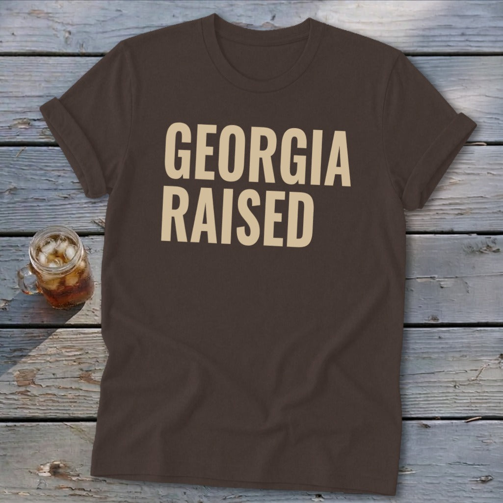 Brown t-shirt with "GEORGIA RAISED" in beige text.