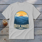 Light gray t-shirt with a vintage nature graphic depicting mountains, a sunrise, and text reading OVER YONDER.