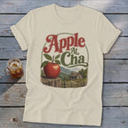 Cream t-shirt featuring a graphic of an apple on a wooden post with mountains and text Apple A Cha.