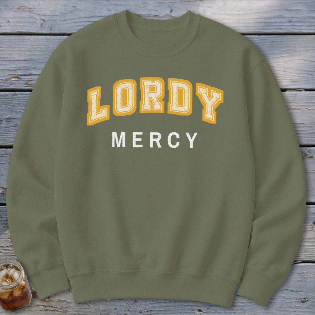 Olive green crewneck sweatshirt with "LORDY MERCY" text in distressed yellow and white lettering.