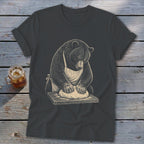 Bear wearing apron kneading dough on a wooden cutting board.