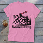 Pink t-shirt with graphic of axe and stacked firewood, text reads "Stacked for the Season".