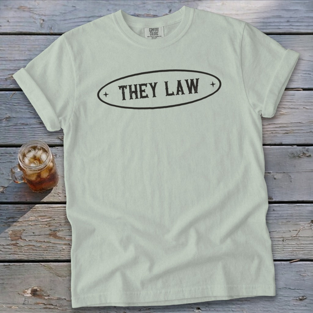 Light blue Comfort Colors t-shirt with "THEY LAW" in a black oval design.