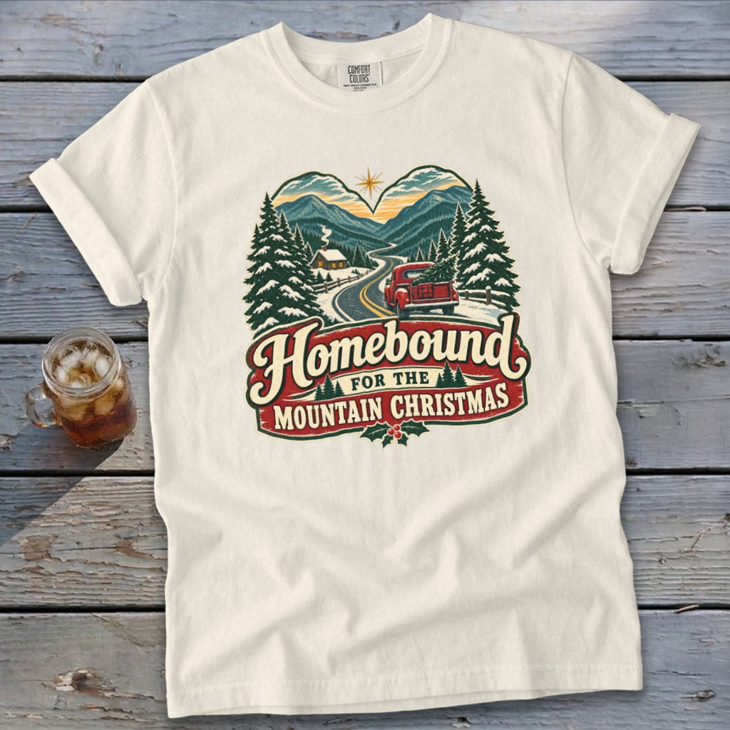 Cream t-shirt with "Homebound for the Mountain Christmas" graphic featuring a truck and mountains.