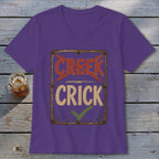 Purple V-neck t-shirt with a distressed sign that reads "CREEK" crossed out and "CRICK" checked.