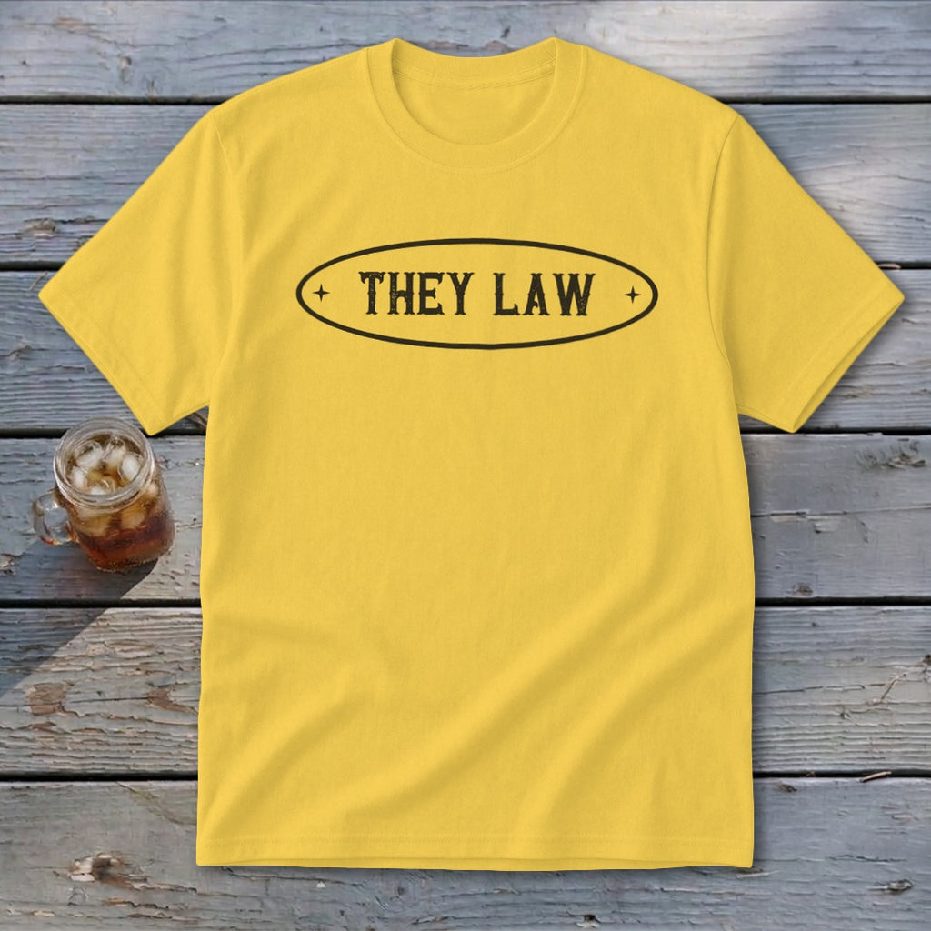 Yellow t-shirt with black oval graphic that reads "THEY LAW".