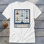 White t-shirt featuring a blue and grey flying geese quilt pattern and the text "FLYING GEESE".