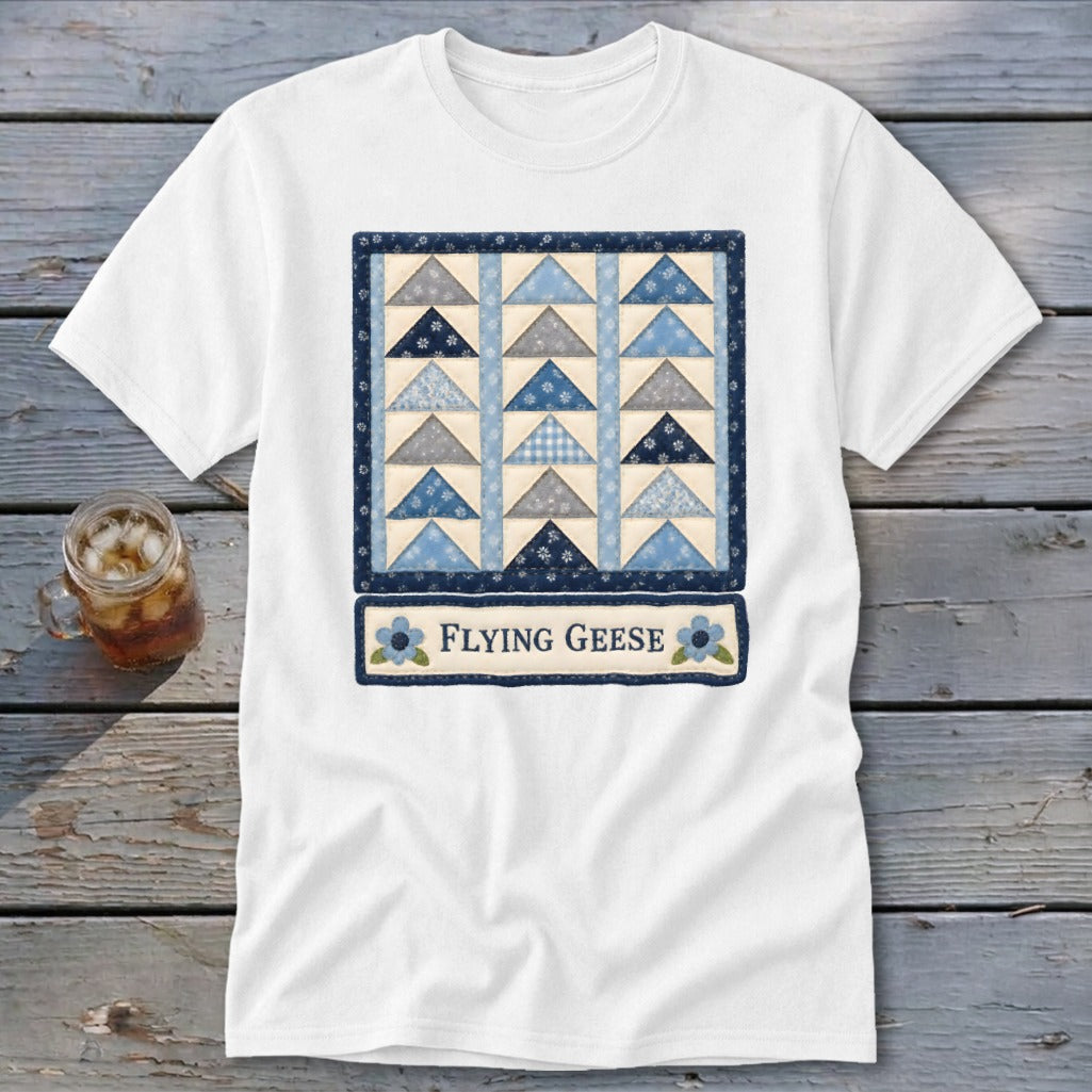 White t-shirt featuring a blue and grey flying geese quilt pattern and the text "FLYING GEESE".