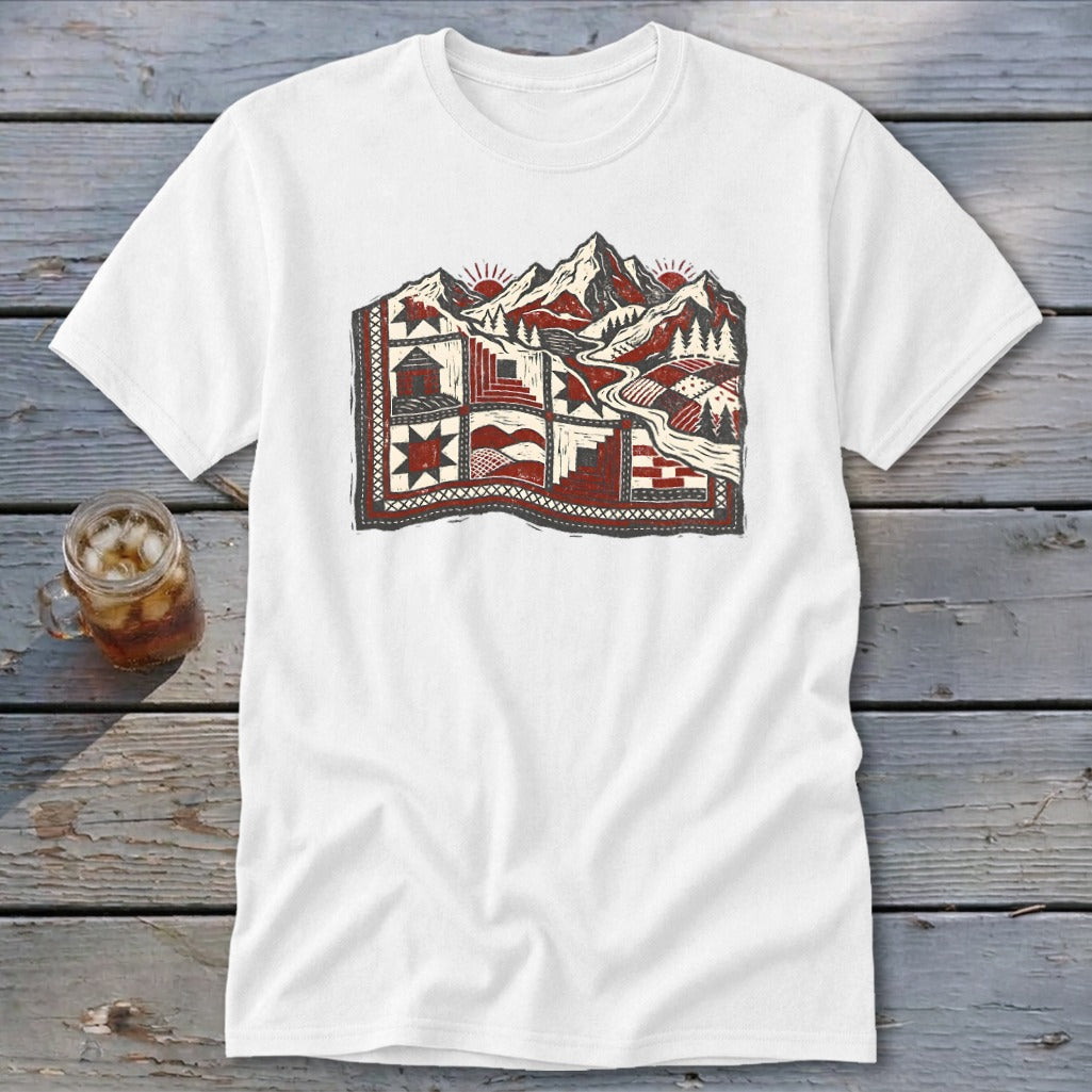 White t-shirt featuring a red, black, and white graphic of mountains transitioning into a patchwork quilt.