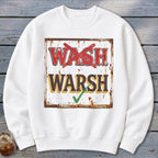 White crewneck sweatshirt featuring a graphic of a distressed sign with red text wash crossed out and brown text warsh checked with green.