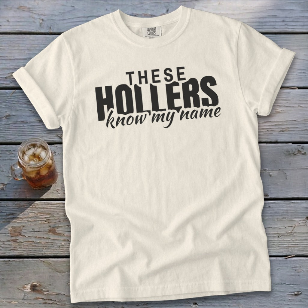 Cream t-shirt with "THESE HOLLERS know my name" graphic print.