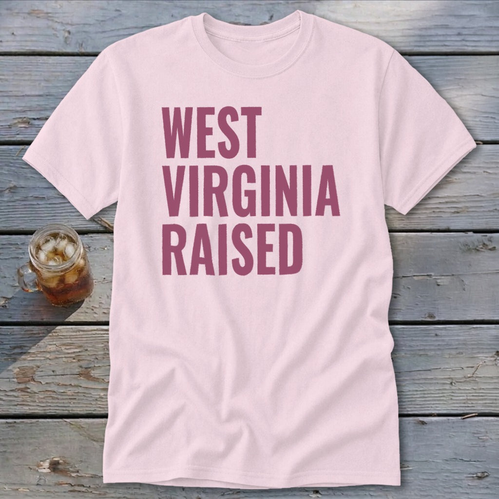 Pink t-shirt with bold magenta text reading "WEST VIRGINIA RAISED."