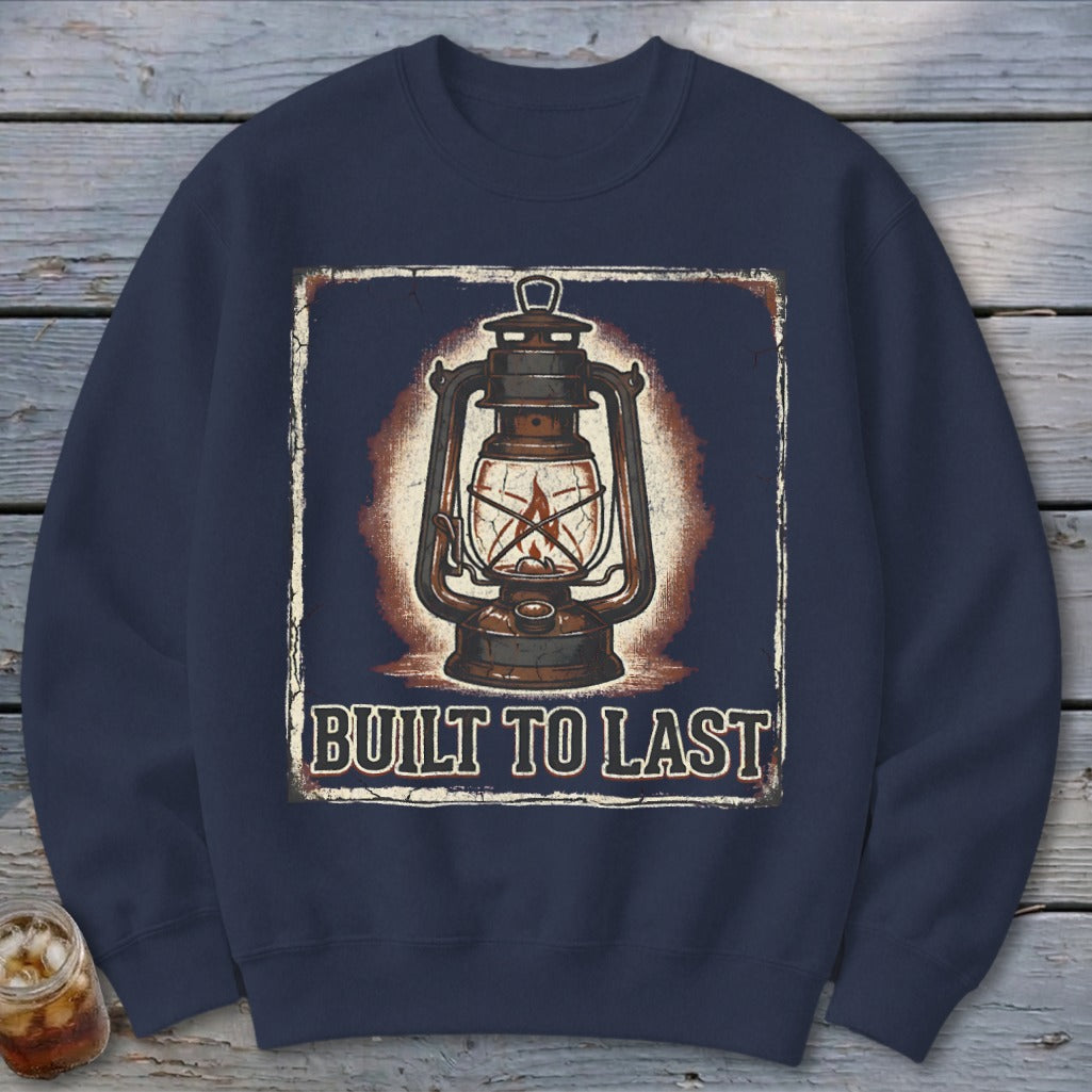 Dark navy sweatshirt with a distressed graphic of an antique lantern and "BUILT TO LAST" text.