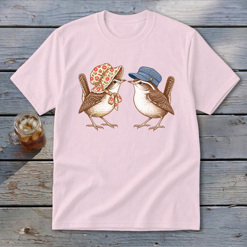 Pink t-shirt with illustration of two wrens, one wearing a bonnet and the other a cap.