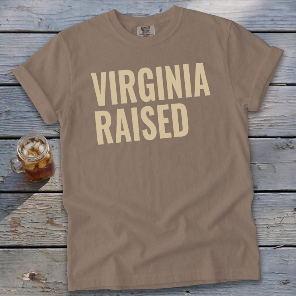 T-shirt with "VIRGINIA RAISED" text in beige on a taupe background.
