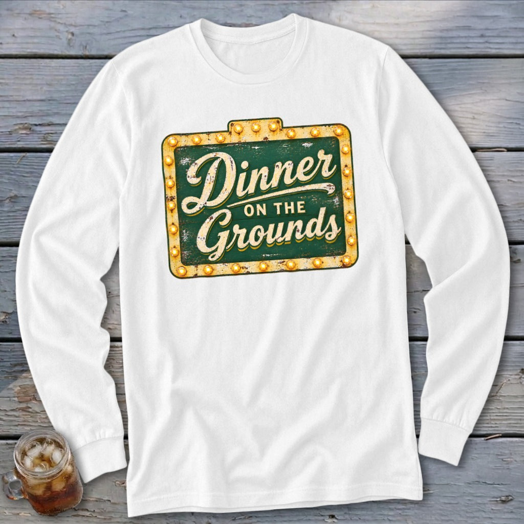 White long-sleeve t-shirt with a vintage green graphic sign reading "Dinner on the Grounds".