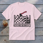 Pink t-shirt with black graphic of stacked firewood and axe, text "STACKED FOR THE SEASON".