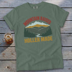 Green t-shirt with "Mountain Raised Holler Made" mountain landscape graphic and Comfort Colors tag.