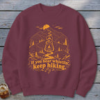 Maroon sweatshirt with orange graphic of mountains, lantern, and "If you hear whistlin', keep hiking." text.