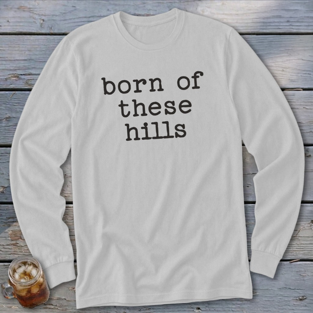 White long-sleeve shirt with "born of these hills" text.
