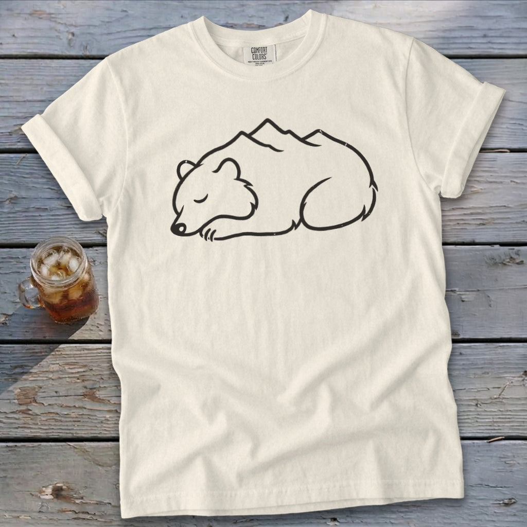 Cream t-shirt with a black outline drawing of a sleeping bear with mountains on its back.