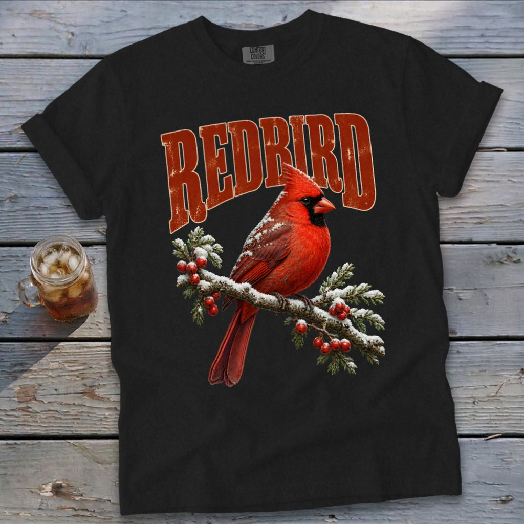 A black t-shirt features a graphic of a red cardinal on a snowy branch with the text "REDBIRD".