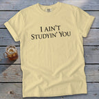 Yellow t-shirt with black text that reads "I AIN'T STUDYIN' YOU".