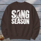 Brown crewneck sweatshirt with white distressed text reading "SANG SEASON" and a digger silhouette.