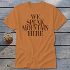 Orange t-shirt with brown text that says "WE SPEAK MOUNTAIN HERE".