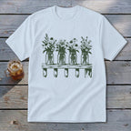 A white short-sleeved t-shirt features a green graphic of four mason jars filled with wildflowers on a shelf.