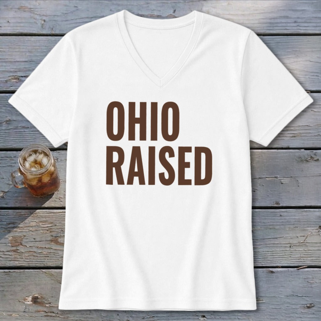 White v-neck t-shirt with brown text "OHIO RAISED" and a glass of iced drink.
