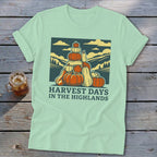 A light green t-shirt featuring a graphic of stacked pumpkins with the text Harvest Days in the Highlands.