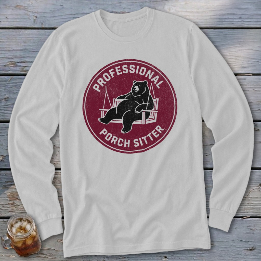 Light grey long-sleeve crewneck shirt with a maroon circular graphic of a bear sitting on a porch swing and the text "Professional Porch Sitter."