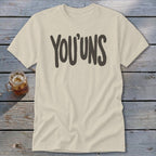 Cream t-shirt with dark gray "YOU'UNS" text and a glass of iced tea.