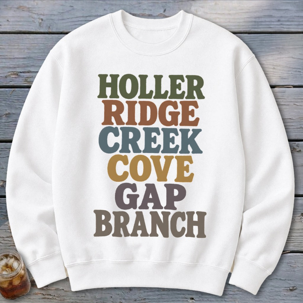 A white crewneck sweatshirt features colorful block lettering spelling out HOLLER RIDGE CREEK COVE GAP BRANCH.